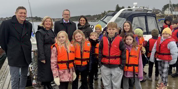 FOTO - Fylkesleder, forbundsleder, statsråd Kari og barn fra Kvernevik skole er samlet på brygga i anledning "dåp" av båt