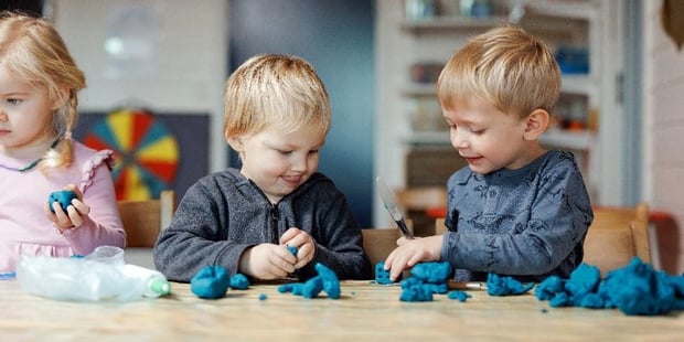 Barnehagebarn leker med plastelina
