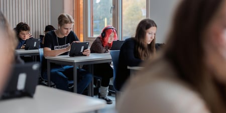 Elever som sitter og jobber i et klasserom