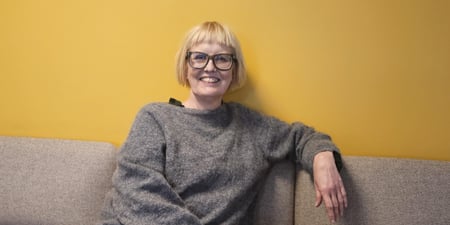 Torill Beitdokken sittende i en sofa, smilende