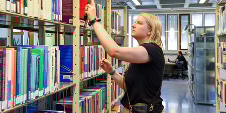 Student på biblioteket på universitetet / høyskolen. Illustrasjonsfoto