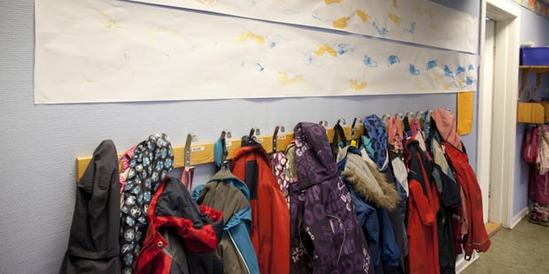 Knaggrekke full av klær i en skolekorridor. Illustrasjonsfoto