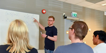 Studenter og foreleser i forelesningssal på universitet / høyskole.