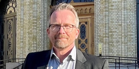 Bilde av Geir Røsvoll foran Stortinget. Leder i Utdanningsforbundet fra 01.01.24. Blid, lukket munn. Smil. Smiler.