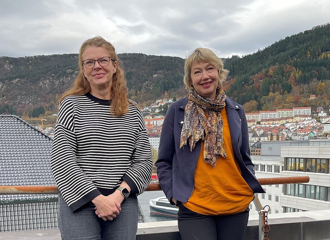 To kvinner som står på en terrasse. Foto