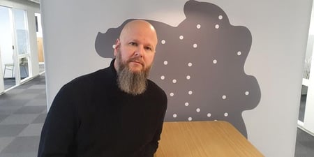 Bilde av Thore Johan Nærbøe, sittende foran et stilisert kart over Innlandet