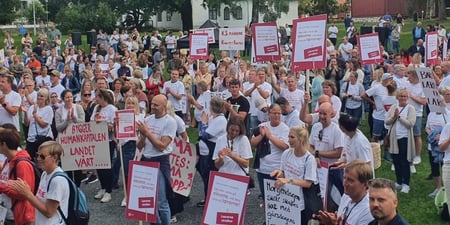 Bilde fra markeringen: Bilde av deltagere foran scena. Mange lærere med plakater og tskjorter med budskap: Lærerne streiker, Bare lærere er lærere, Nok er nok.