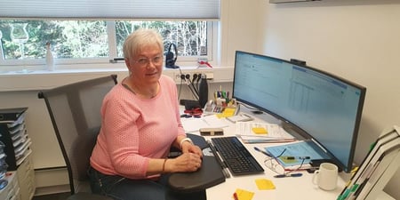 Bilde av Marit Gylstrøm sittende ved pulten sin.