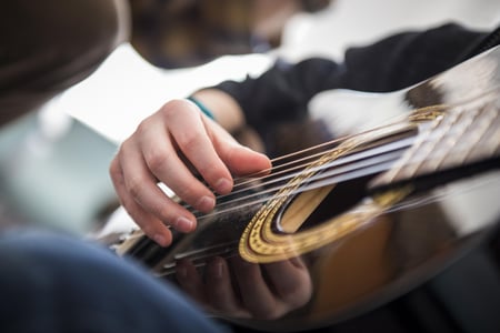 Illustrasjonsbilde av hånd som spiller på gitarstrenger