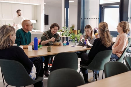 Bildet viser lærere ved Oksenøya barneskole. Vi er inne i lærerværelset, hvor det er lunsjpause. Det er god stemning og lærerne smiler.