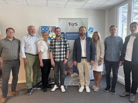 Foto av alle partene i FUS-oppgjøret oppstilt. Totalt åtte personer.