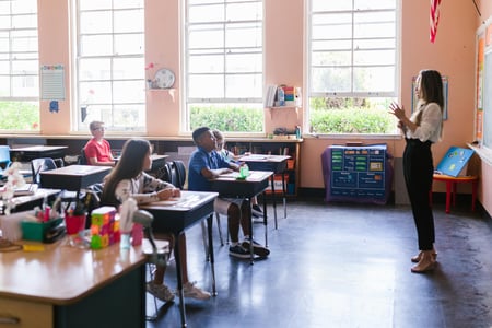 Kvinne underviser elever i klasserom