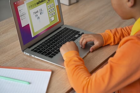 Bildet viser en elever ved Oksenøya barneskole. Hun skriver i en mattebok.