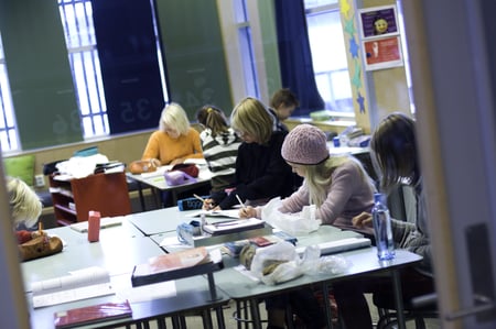 Elev sitter alene ved et bord. Foto.