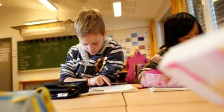 Ung gutt som leser i en bok. Foto.