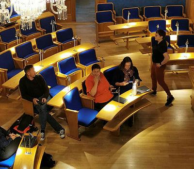 Bilde av mennesker som diskuterer i bystyresal