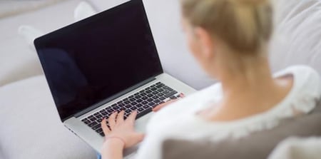 Kvinne skriver på pc. Foto. 
