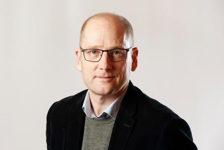 Mann med briller ser på kamera