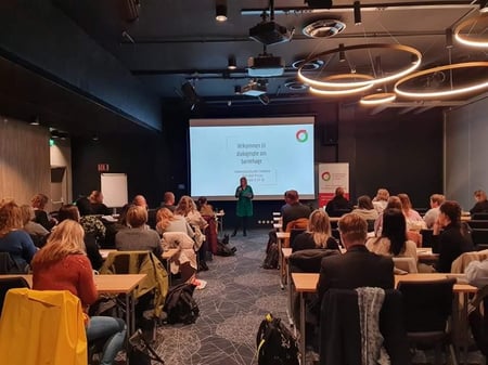 Gruppe og foredragsholder i konferansesal