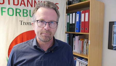 Bilde av fylkesleder Geir Røsvoll foran en bokhylle og Utdanningsforbundet Trøndelags fane. FOTO
