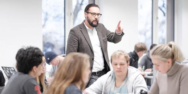 Mannlig lærer som underviser i et klasserom. Foto.