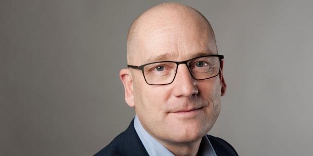 Mann med briller ser rett på kameraet