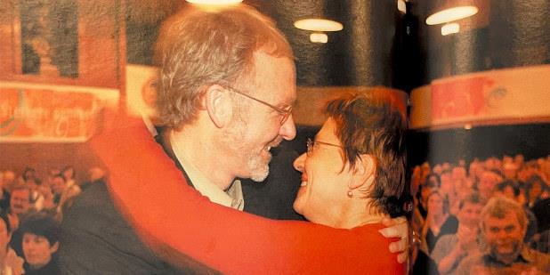 Anders Folkestad og Helga Hjetland på vei inn i en varm klem med Kongressalen bak dem. I bakgrunnen skimtes delegater som klapper. Foto.