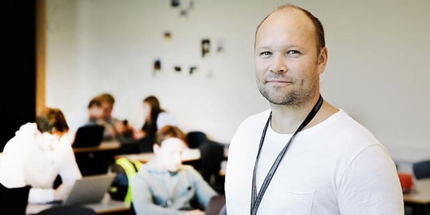 Kvinnelig lærer i skolekorridor. Foto