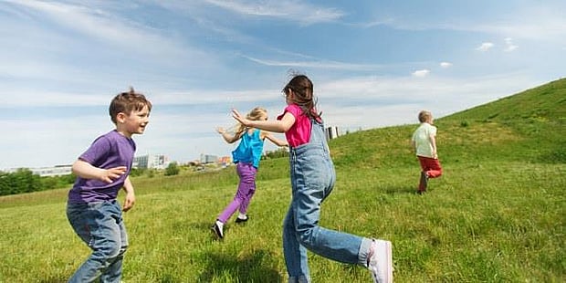 Barn som leker og løper i sola. Illustrasjinsfoto