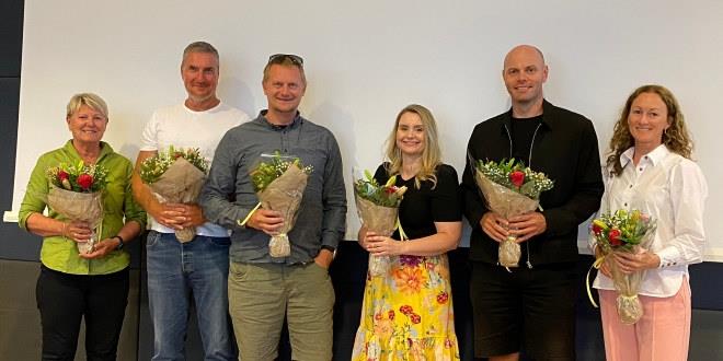 Bilde av 6 personer som takkes av med blomster