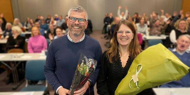 Vi ser bilde fra årsmøtet i Arendal. Bilde av Geir Helge Lindgren som ble gjenvalgt som lokallagsleder. Han gratuleres av Sheila Vaage Benestad, fylkesstyrets representant på årsmøtet. Begge er avbildet i halvfigur.