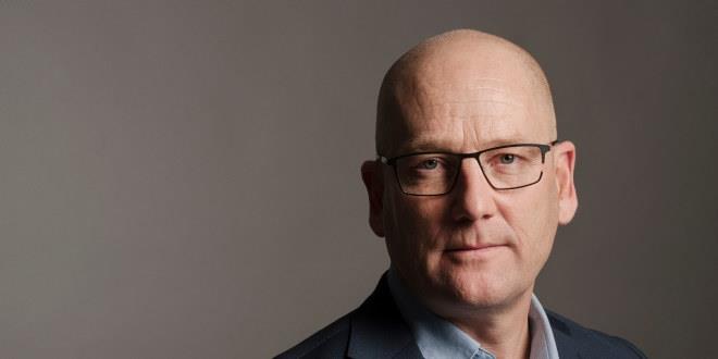 En alvorlig Steffen Handal, med briller og i pentøy, ser alvorlig inn i kameraet.