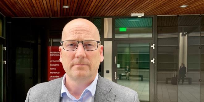Steffen Handal står utenfor en dør på Thon Hotel Opera i Oslo. Han synes fra hals og opp. 
