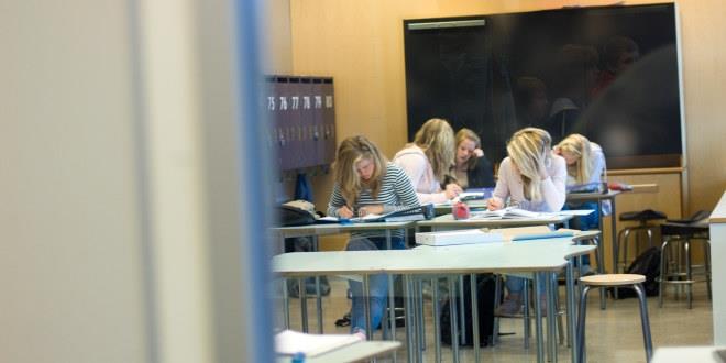 Biletet viser eit klasserom med nokre få elevar og fleire tomme pulter.