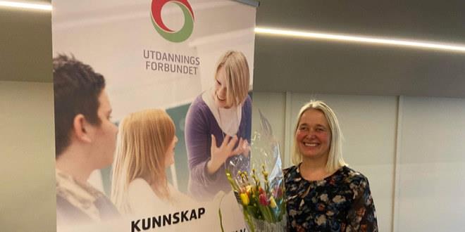 Portrettbilde av Anne Torhild Andersen. Hun er avbildet med blomster i hånda.