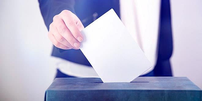 Bilde av stemmeseddel som blir lagt i en stemmeurne.