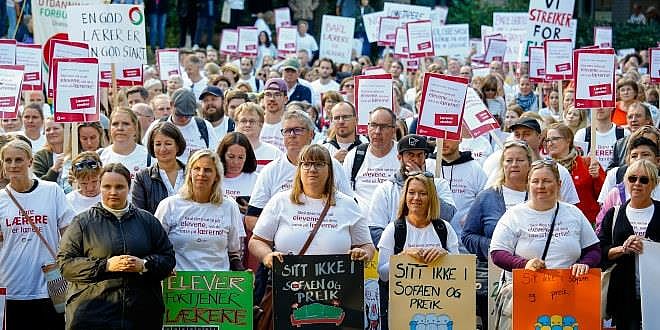 En stor gruppe med streikende lærere vises, de fleste med hvite streiket-skjorter og plakater. Foto: Tore Skaar