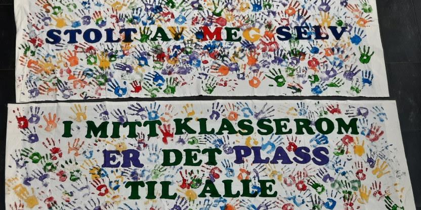 Foto av to bannere med teksten "Stolt av meg selv" og "I mitt klasserom er det plass til alle"