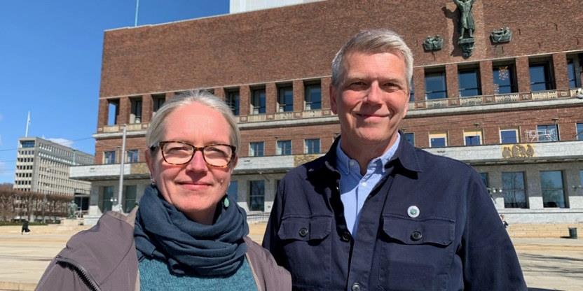Kvinne og mann foran rådhuset i Oslo som ser mot kamera.