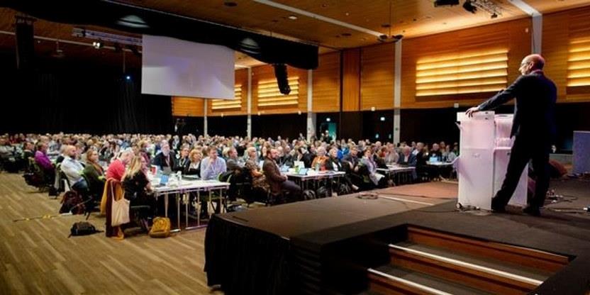 Foto av landsmøtesalen, med delegater og Steffen Handal på talerstolen