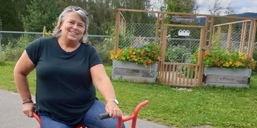 Bilde av Bente Kampesveen på sykkel foran en barnehage