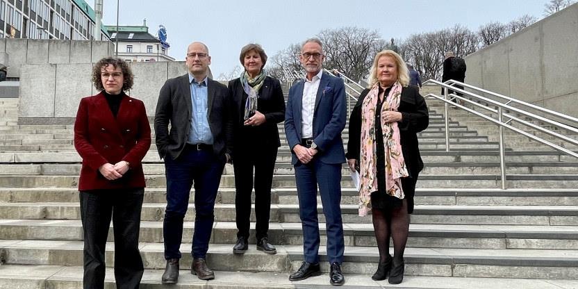 Fem mennesker samlet på en trapp nedenfor Utenriksdept.
