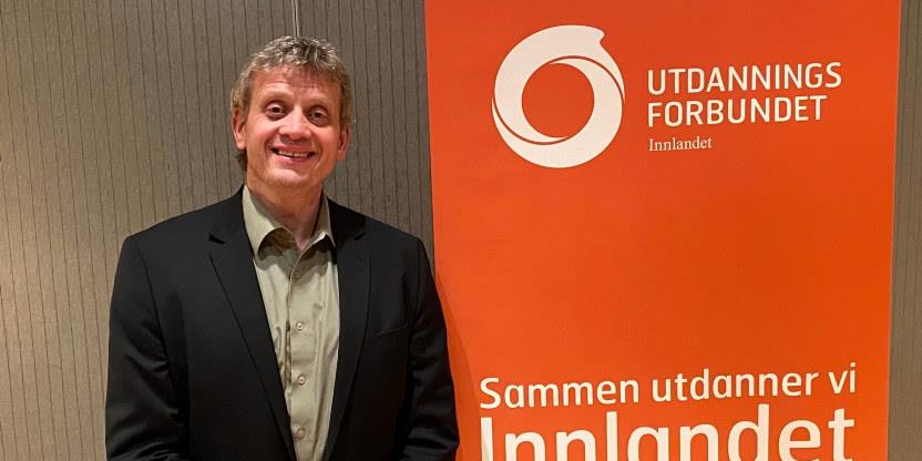 Bilde av Lars Frode Finstad ved siden av en roll up med Utdanningsforbundet Innlandet på.