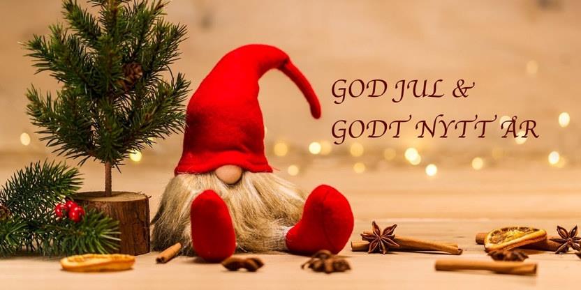 Et jule stemningsbilde med nisse, grantre og julelys. Tekst på bildet er god jul og godt nytt år.
