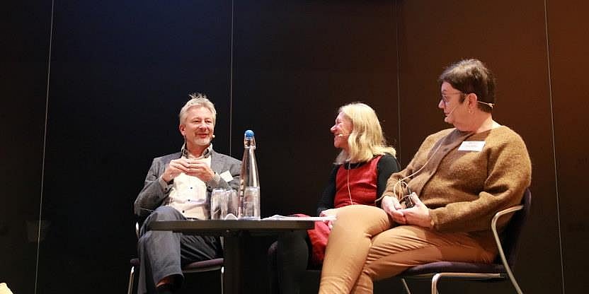 Bilde av Tormod Korpås, Marit Aas og Bente Aalberg i samtale på en scene. Alle sittende rundt et lite bord.