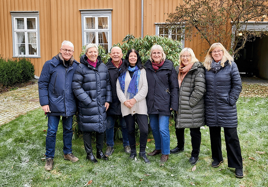 Pensjonistrådets medlemmer står på en rekke i fint novemberlys, i bakgården til Hornemannsgården.