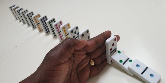 Vi ser dominobrikker der halvparten er i ferd med å falle